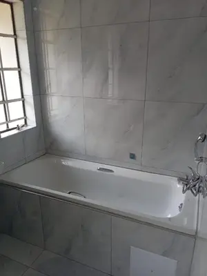 a white bath tub in a bathroom with a window at Crystal Park Guest house in Benoni