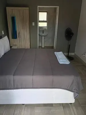 a large bed in a bedroom with a window at Crystal Park Guest house in Benoni