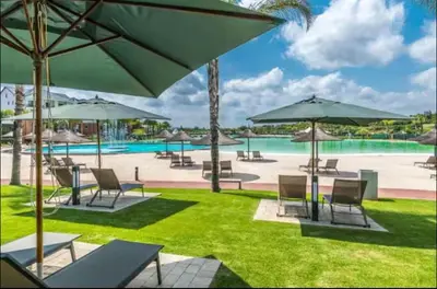 a resort with a pool with chairs and umbrellas at The Blyde lagoon Penthouse in Pretoria