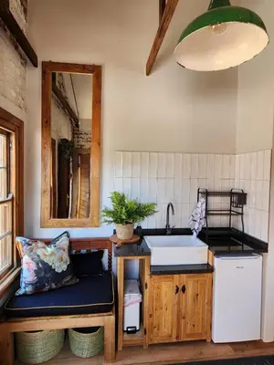 a kitchen with a sink and a counter with a mirror at The Upper Room in Polokwane