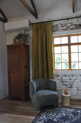 a living room with a chair and a window at The Upper Room in Polokwane