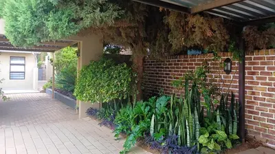 a brick wall with a garden of plants at Eleven on Coulbrough in Midrand