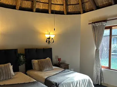 a bedroom with two beds and a window at Koro Lodge in Modimolle
