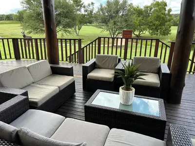 a patio with couches and chairs and a table at Koro Lodge in Modimolle