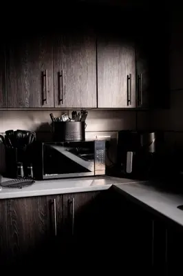 a kitchen with wooden cabinets and a microwave at Eliá Dendró Víla in Lydenburg
