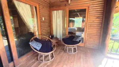 two chairs sitting on the porch of a cabin at Nomads Rest in Sterkspruit