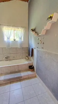 a bathroom with a bath tub and a window at Nomads Rest in Sterkspruit