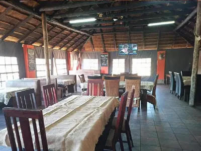 a dining room with a long table and chairs at Rondevue Game Lodge in Warmbaths