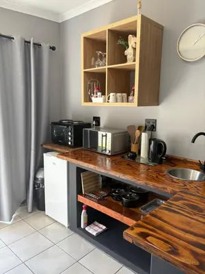 a kitchen with a counter with a microwave and a sink at Be Still Haven in Polokwane