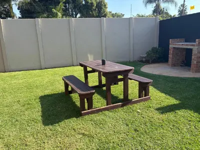 a picnic table and two benches in a yard at Be Still Haven in Polokwane