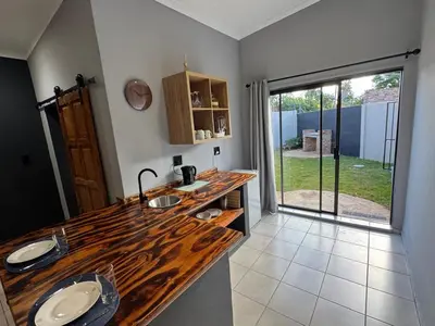 a kitchen with a wooden counter top and a large window at Be Still Haven in Polokwane