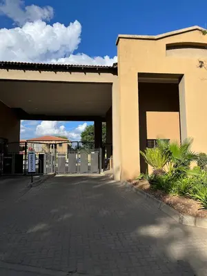 a building with a gate and a parking lot at Elephant Springs in Polokwane