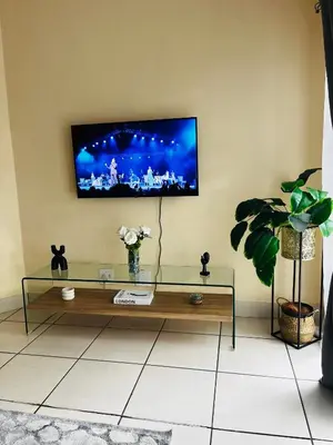 a living room with a television on a wall at Elephant Springs in Polokwane