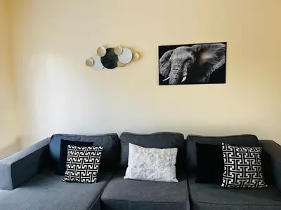 a living room with a couch and an elephant on the wall at Elephant Springs in Polokwane