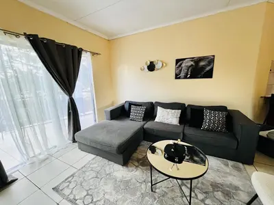 a living room with a couch and a table at Elephant Springs in Polokwane