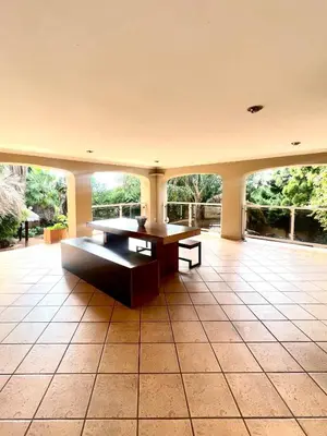 a large room with a table and benches on a tile floor at Windsor villa in Pretoria