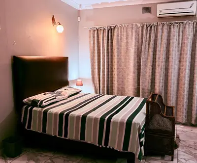 a bedroom with a bed with a striped blanket at El Roi apartment in Middelburg