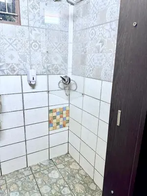a bathroom with a shower with white tiles at El Roi apartment in Middelburg