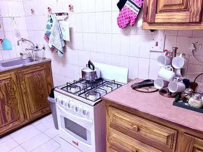 a kitchen with a white stove top oven next to a counter at El Roi apartment in Middelburg