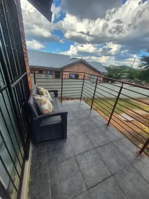 a balcony with a couch and a view of a field at Hazyview Hideaway in Hazyview