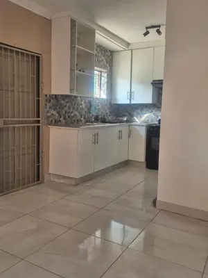 a large kitchen with white cabinets and a tile floor at Hazyview Hideaway in Hazyview