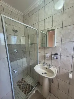a bathroom with a sink and a glass shower at Hazyview Hideaway in Hazyview