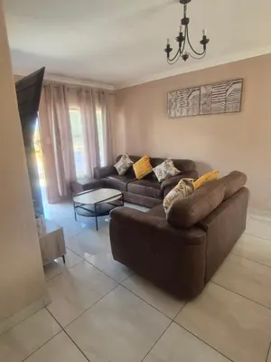 a living room with two couches and a chandelier at Hazyview Hideaway in Hazyview
