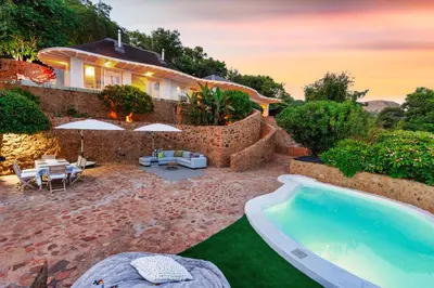 a house with a swimming pool in the yard at Enso Botanico in Hartbeespoort