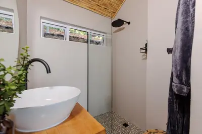 a bathroom with a white tub and a sink at Enso Botanico in Hartbeespoort