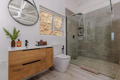 a bathroom with a toilet and a shower and a mirror at Enso Botanico in Hartbeespoort