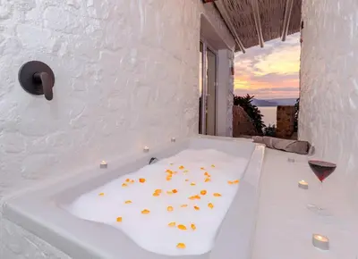 a bath tub with flowers on it with a glass of wine at Enso Botanico in Hartbeespoort