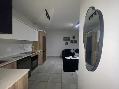 a kitchen with a mirror and a couch in a room at Luxor Sky Waterfall city in Midrand