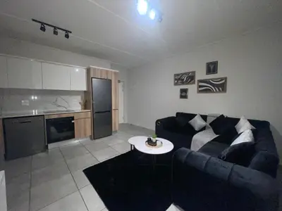 a living room with a couch and a table at Luxor Sky Waterfall city in Midrand