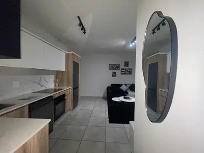 a kitchen with a mirror and a couch in a room at Luxor Sky Waterfall city in Midrand