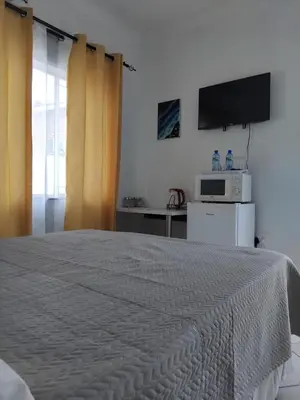 a bedroom with a large bed with a tv on the wall at Claremont Secured unit in Pretoria