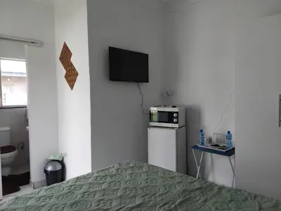a bedroom with a bed and a television on a wall at Claremont Secured unit in Pretoria