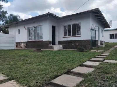 a white house with a lawn in front of it at Claremont Secured unit in Pretoria
