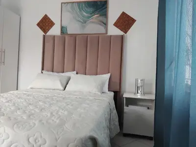 a bedroom with a white bed with a pink headboard at Claremont Secured unit in Pretoria