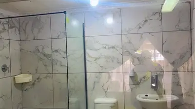 a bathroom with a toilet and a shower at ekhaya guesthouse in Secunda