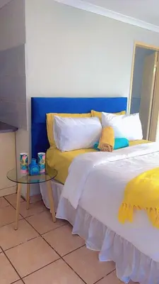 a bedroom with a bed and a glass table at ekhaya guesthouse in Secunda