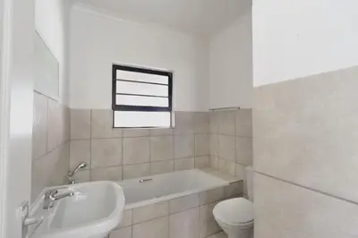 a bathroom with a tub and a toilet and a sink at Cloveridge 104 in Benoni