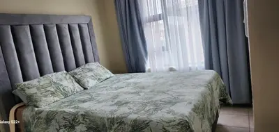 a bedroom with a bed and a window with curtains at Cloveridge 104 in Benoni
