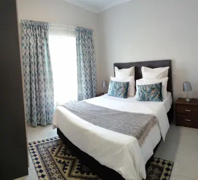 a bedroom with a large bed and a window at Gorgeous Teres place in Midrand