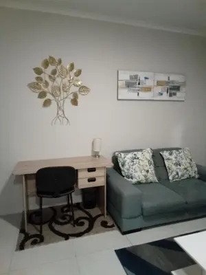 a living room with a desk and a couch at Gorgeous Teres place in Midrand