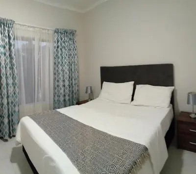a bedroom with a large bed and a window at Gorgeous Teres place in Midrand