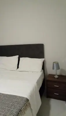 a bedroom with a bed and a night stand with a lamp at Gorgeous Teres place in Midrand