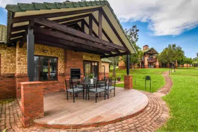 a patio with a table and chairs on a brick building at Peace and Comfort - Greenway Woods in White River
