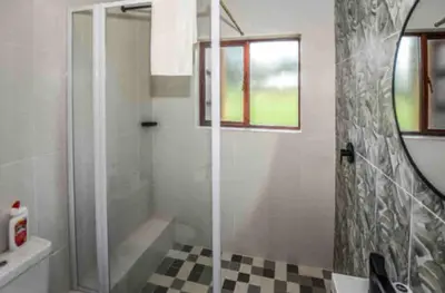 a bathroom with a shower and a sink and a mirror at Peace and Comfort - Greenway Woods in White River