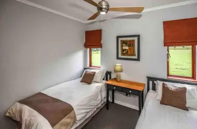 a bedroom with two beds and a desk at Peace and Comfort - Greenway Woods in White River