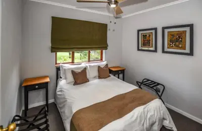a bedroom with a bed with two tables and a window at Peace and Comfort - Greenway Woods in White River